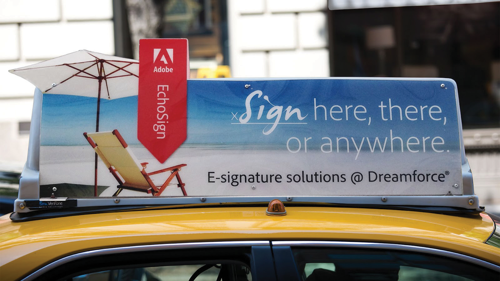 An execution of the creative on a cab. The advert is of a sunny beach, with the message "Echo Sign" pointing to a deck chair.
