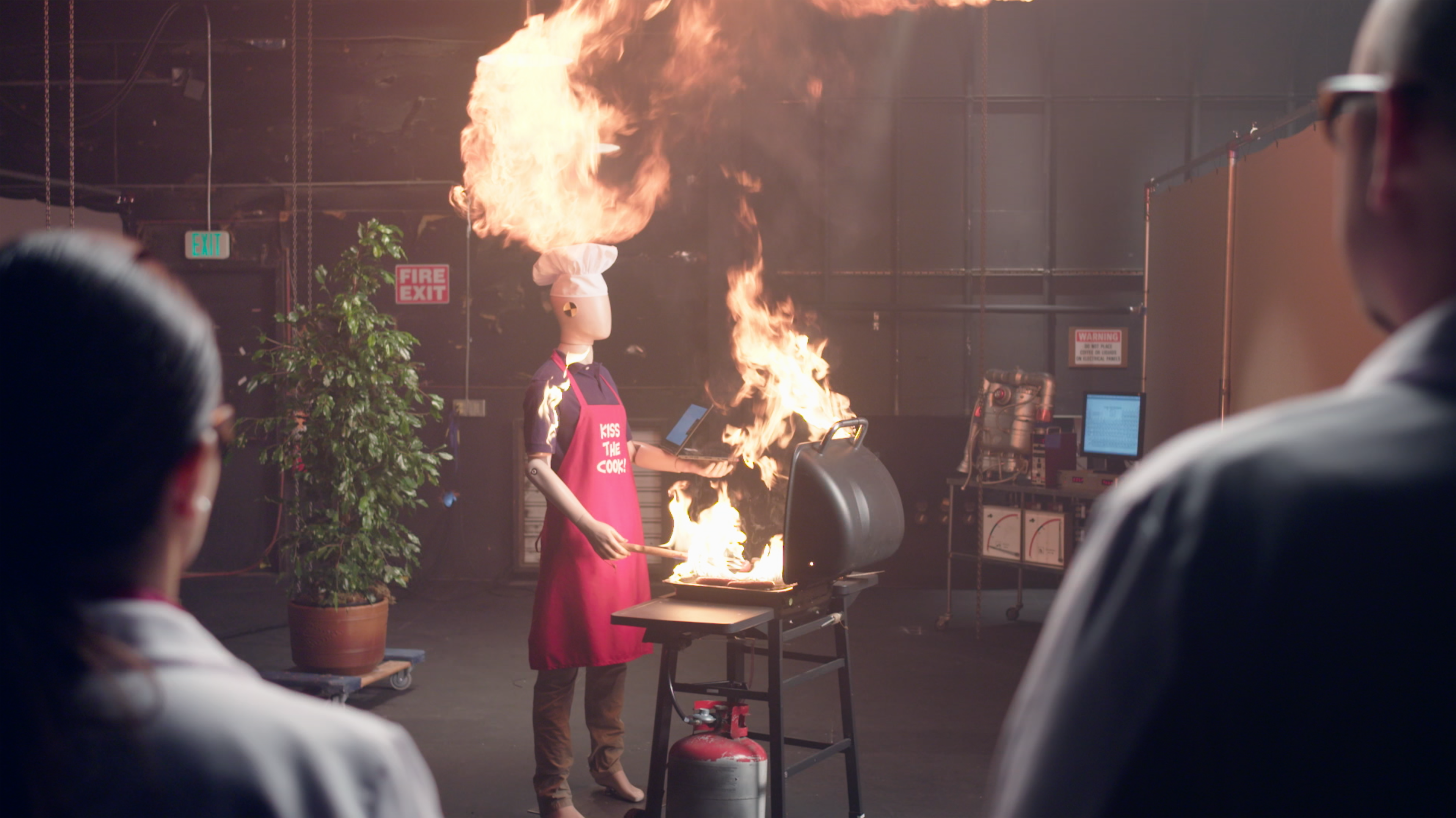 Picture of mannequin on fire next to a bbq in a lab